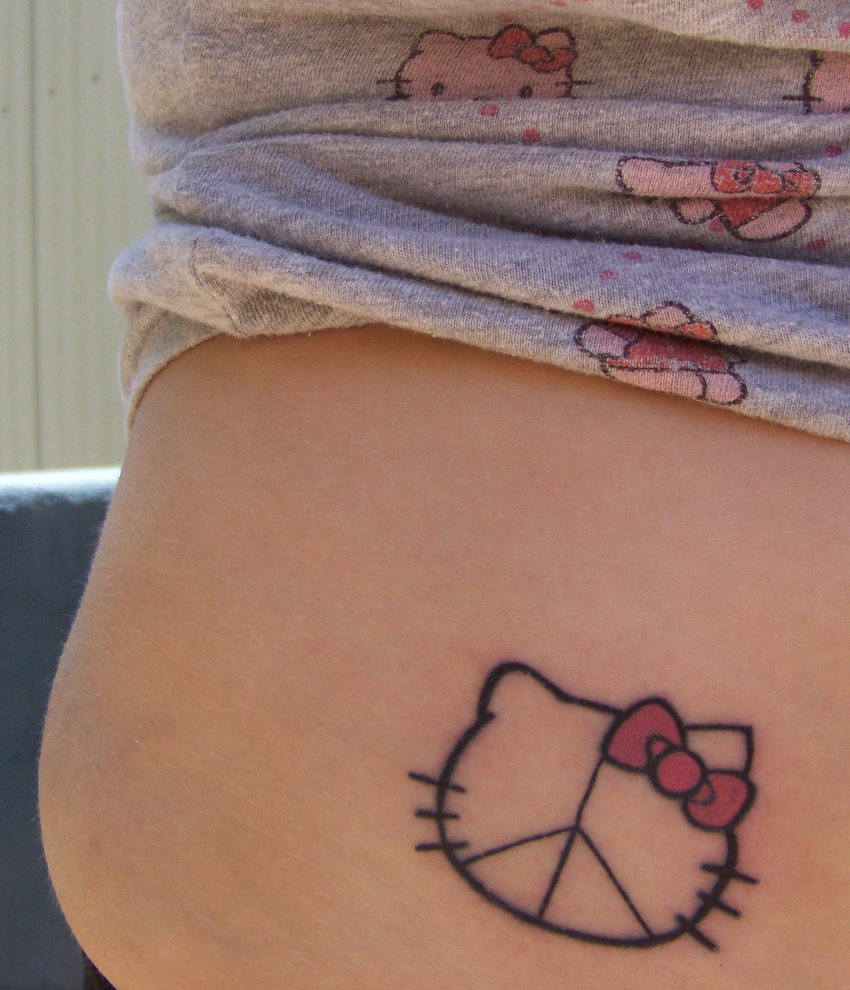 Hello Kitty minimalistyczny tatuaż